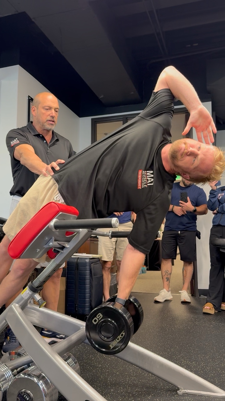 Client demonstrating a strength movement with a MAT practitioner nearby